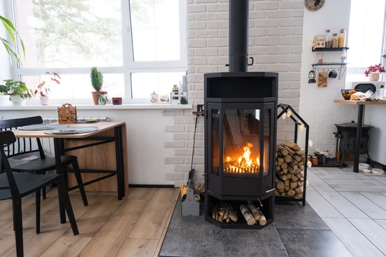 Intérieur moderne avec poêle à bois central en fonctionnement, flammes visibles